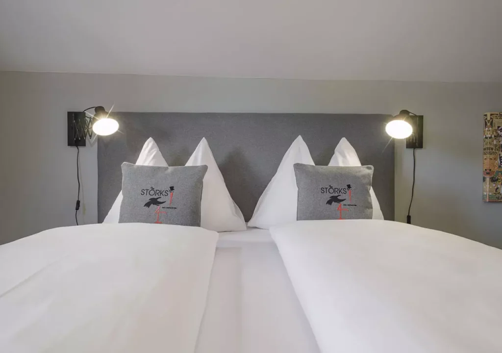 Bild zeigt The STORKS Double Deluxe Zimmer mit Bett und Polstern